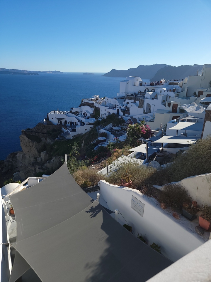 Vue de falaise avec bâtiments blancs et mer bleue.
