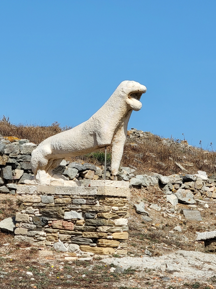 Ancienne statue de pierre d'un lion dans un champ ouvert.