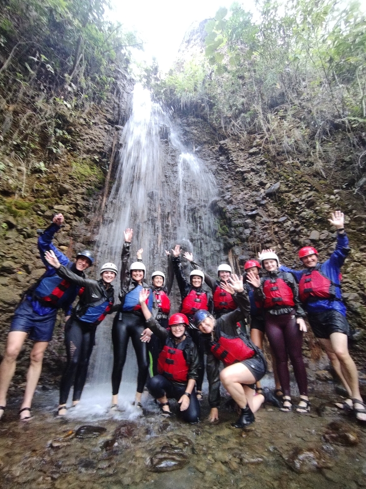 Photo de groupe de rafteurs près d'une cascade.