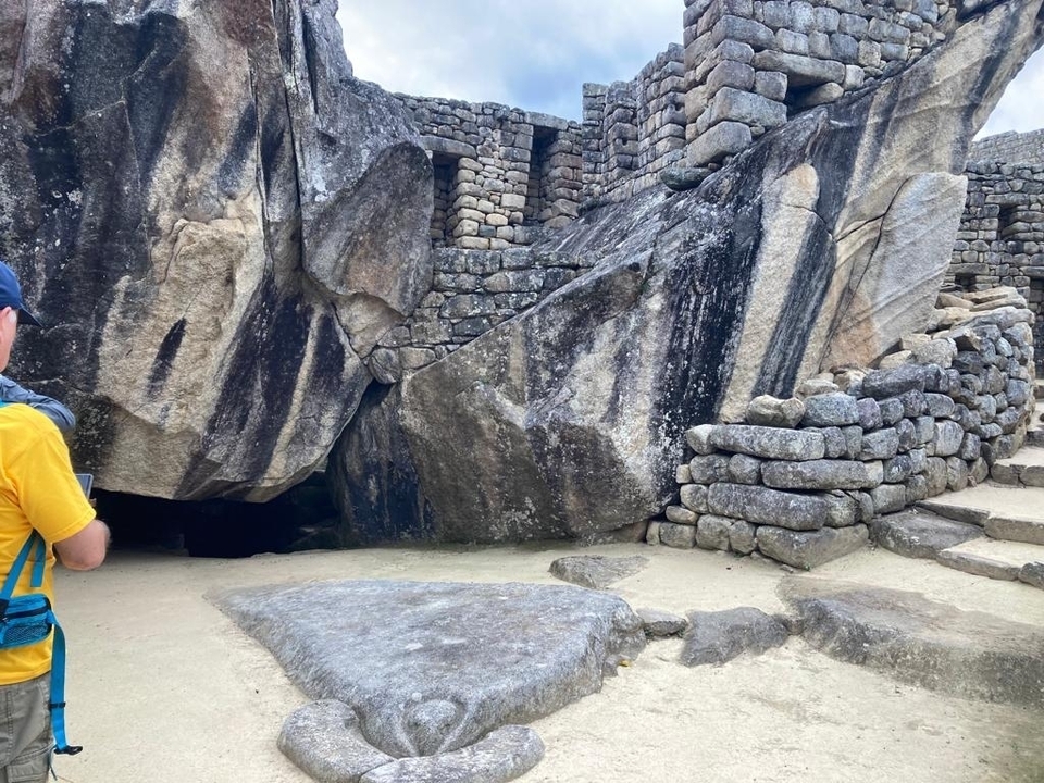 Ruines de pierre avec une personne en veste jaune.
