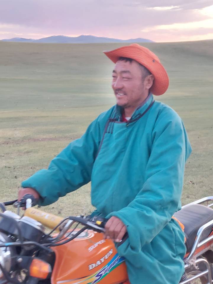 Homme conduisant une moto en tenue traditionnelle.