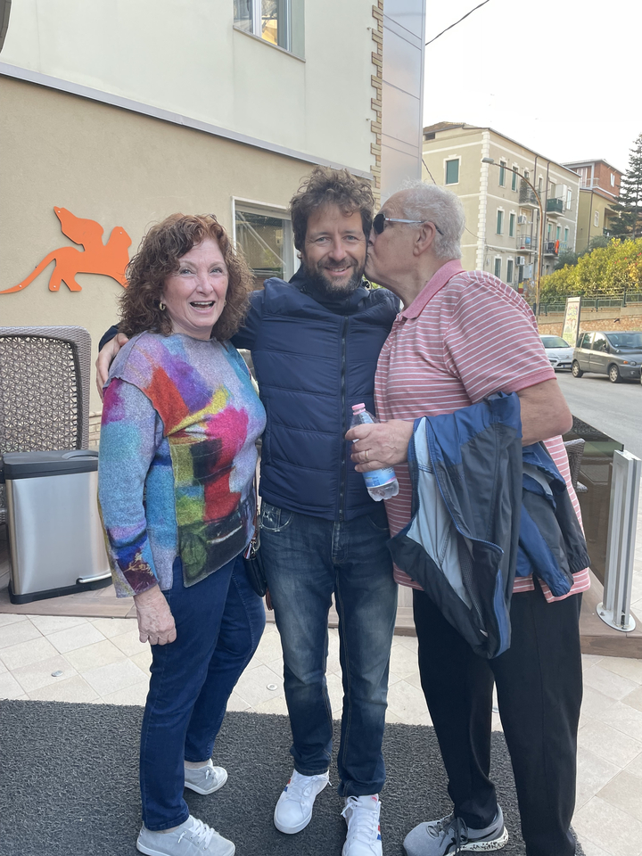 Trois personnes posant joyeusement dans une rue.
