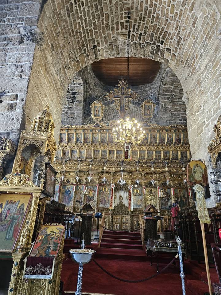 Intérieur d'église orné avec des icônes et des lustres.