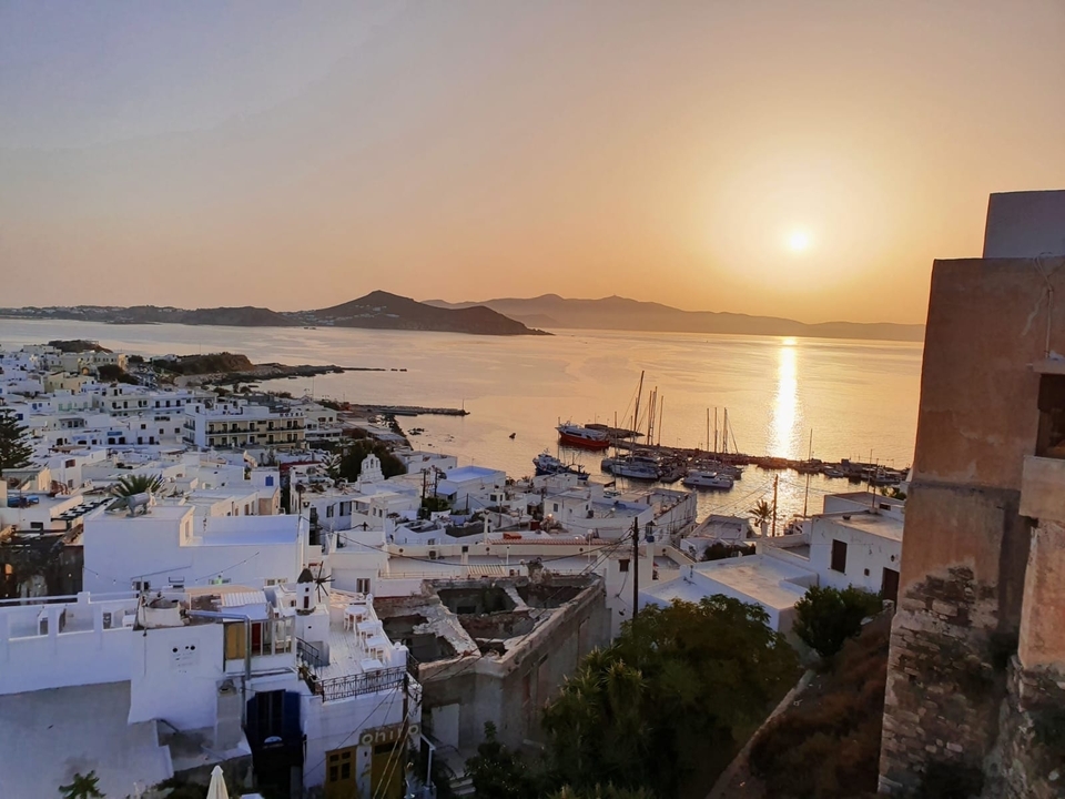 Vue du coucher de soleil sur une ville côtière avec des bateaux.