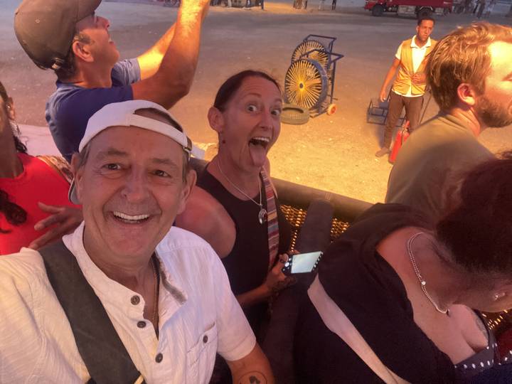 Eine Gruppe von Menschen mit lächelnden Gesichtern im Sonnenlicht.