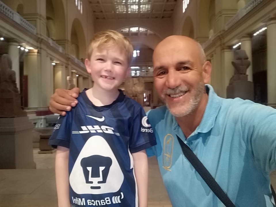 Deux personnes souriantes à l'intérieur, entourées de sculptures.