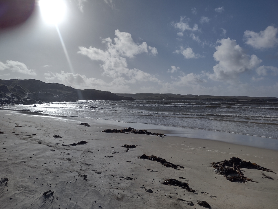 Plage de sable avec des vagues et un ciel dramatique