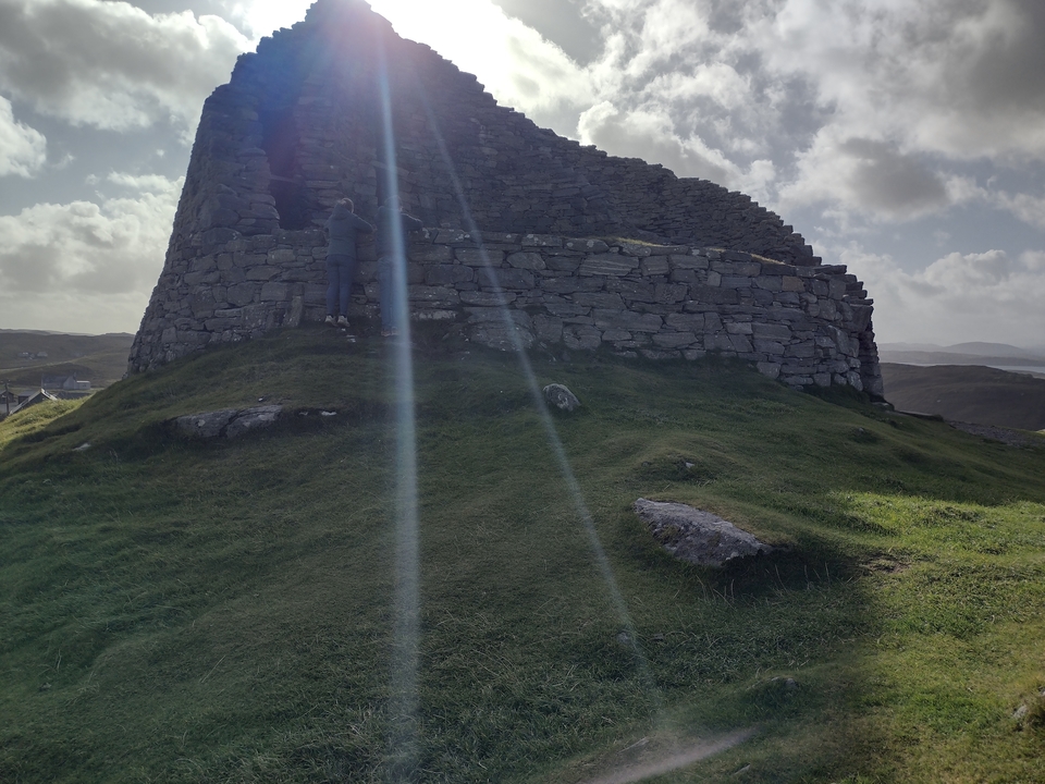 Structure circulaire en pierre avec de la mousse sur le flanc de colline