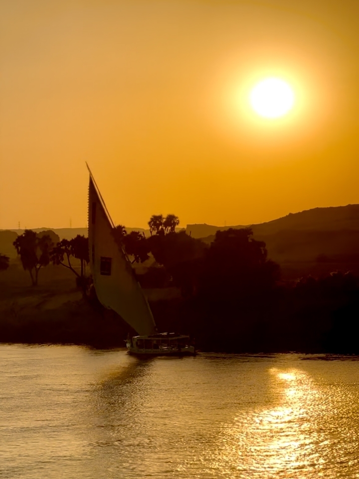 Silhouette d'une voile de bateau au coucher du soleil.