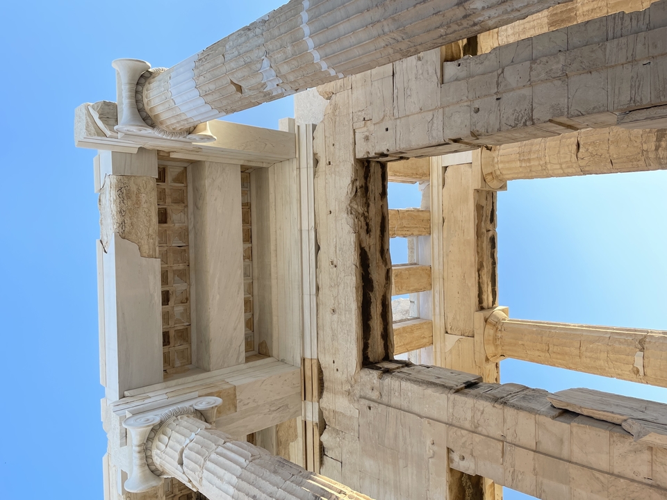 Anciennes colonnes de pierre sous un ciel bleu clair.