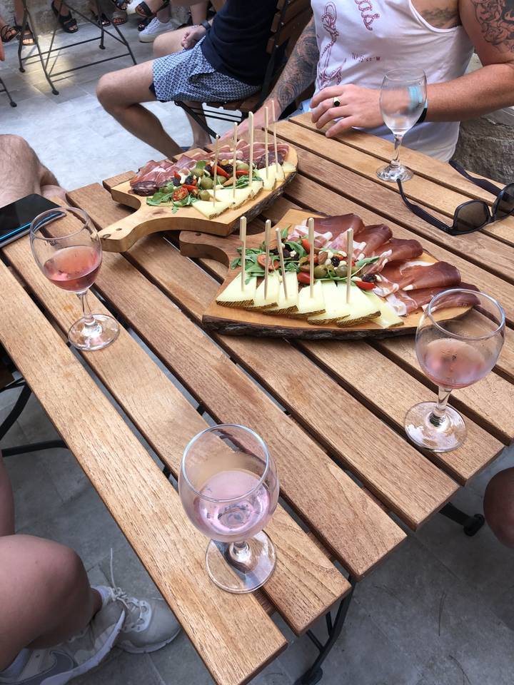 Table avec des assiettes de nourriture et des boissons, avec des personnes qui dînent.