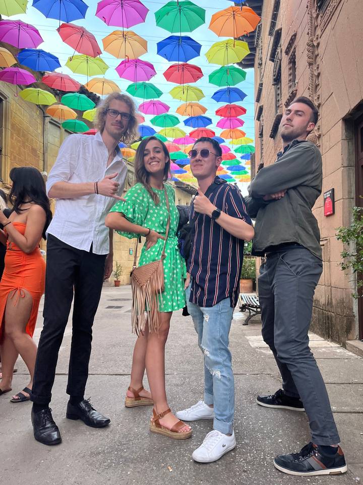 Photo de groupe sous des parapluies colorés dans la rue.
