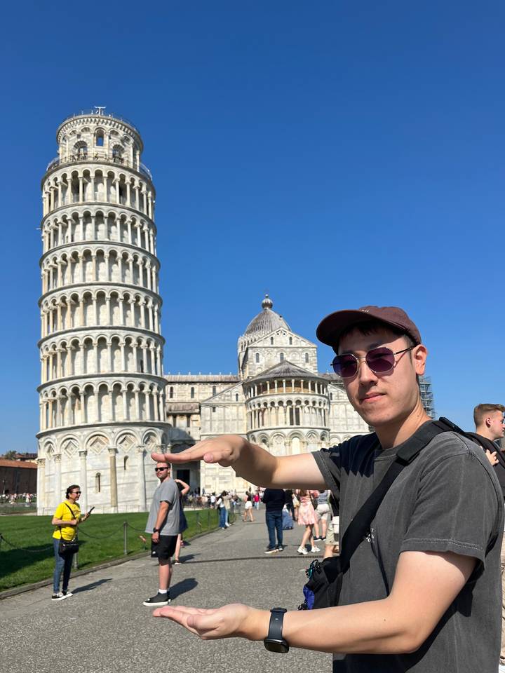 Personne posant devant la tour penchée de Pise.