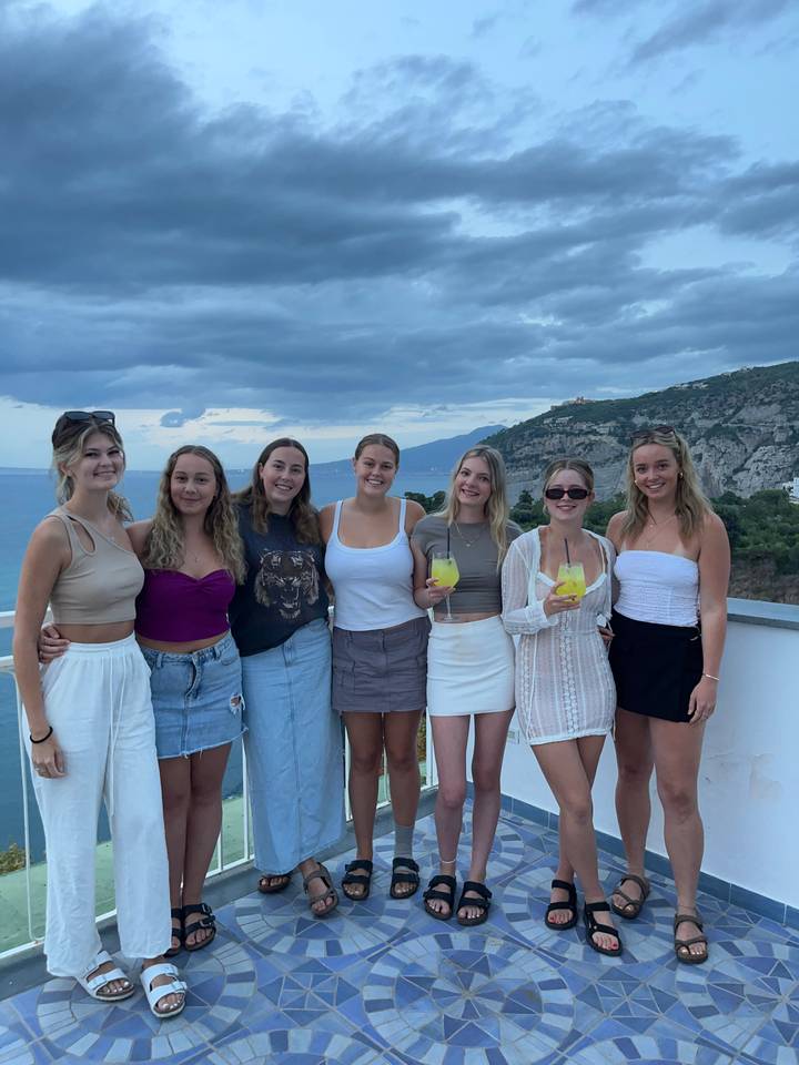 Un groupe de personnes sur une terrasse avec vue sur la côte.