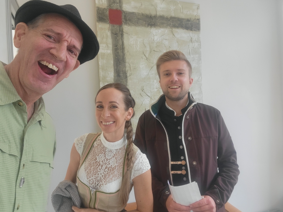 Trois personnes souriantes dans un cadre intérieur décontracté.