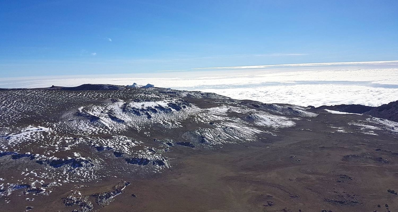 Vaste paysage avec des pics de montagnes enneigés au-dessus des nuages.