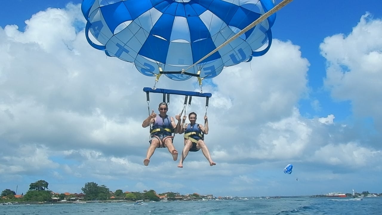 Parapentistes suspendus au-dessus de la mer avec une vue panoramique.