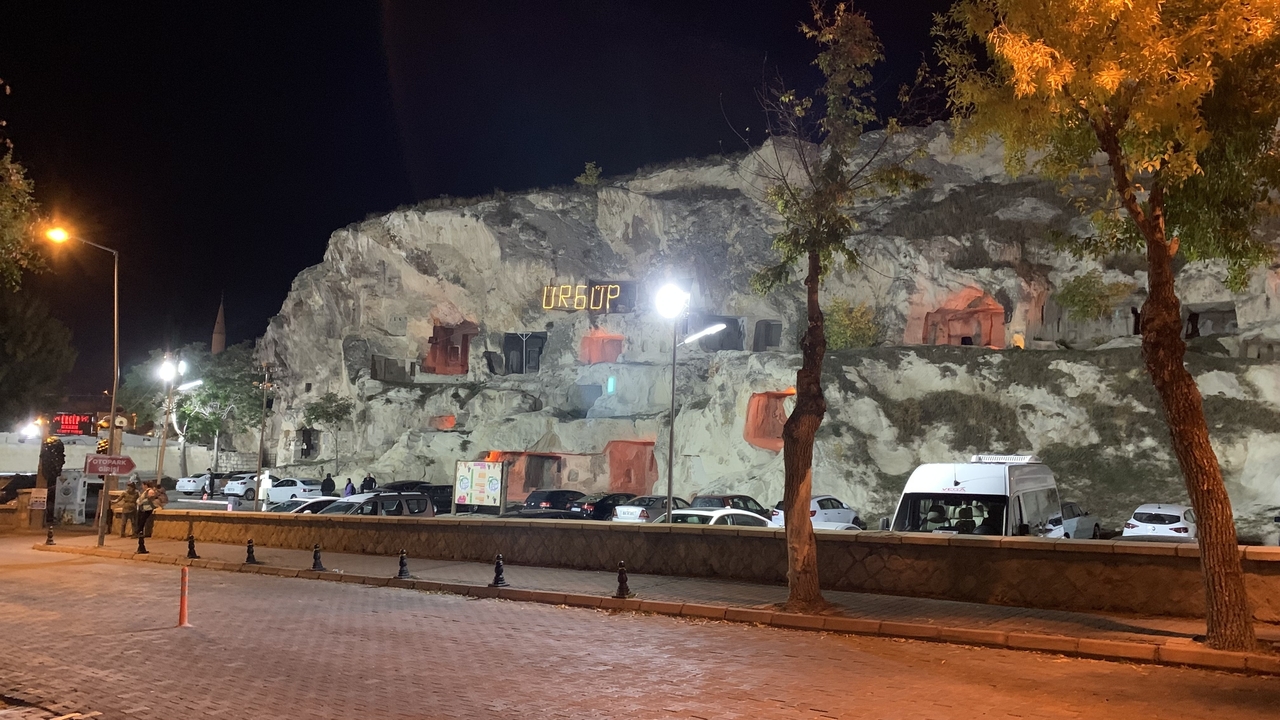 Formations rocheuses avec des sculptures illuminées la nuit.