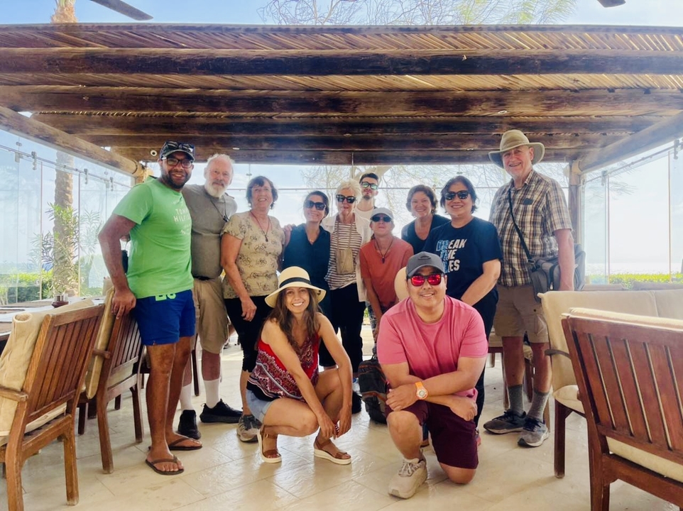 Groupe de personnes posant sous un auvent en bois.