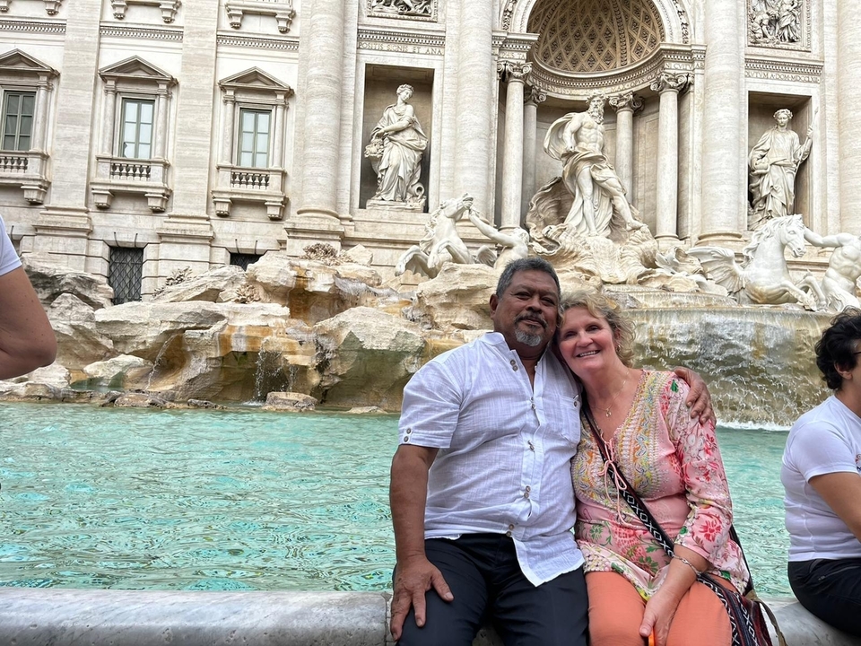Couple posant devant une fontaine célèbre.