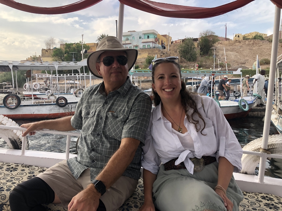 Couple assis sur un bateau avec des bâtiments en arrière-plan.