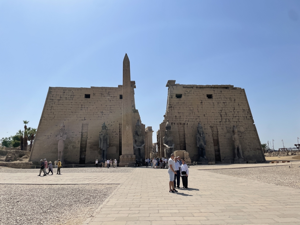 Des visiteurs à l'entrée d'un grand temple antique.