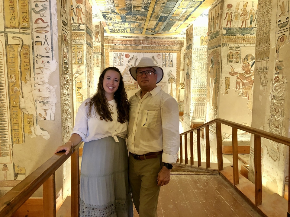 Deux personnes debout à l'intérieur d'un bâtiment historique avec des fresques.