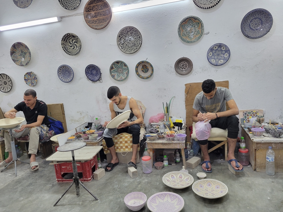 Handwerker, die in einem Atelier an Töpferwaren arbeiten.