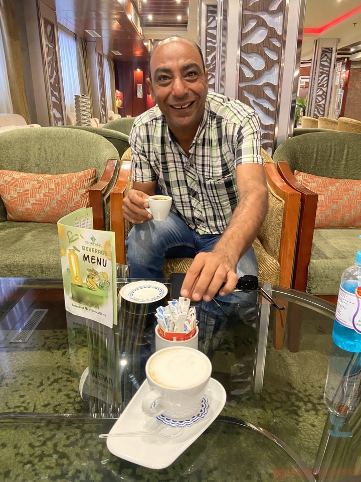 Personne assise à l'intérieur avec une carte des boissons et une tasse.