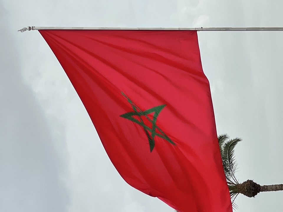 Marokkanische Flagge vor einem bewölkten Himmel.