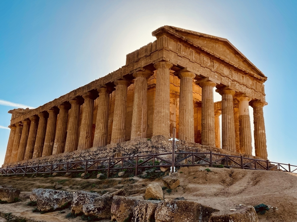 Un temple grec antique avec des colonnes doriques sous un ciel dégagé.