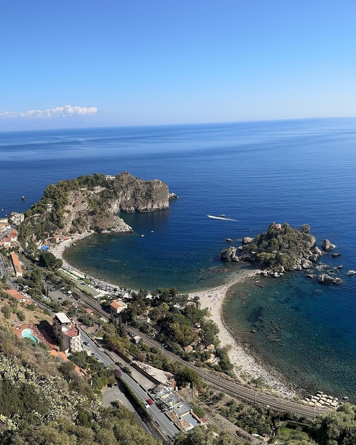 Une vue aérienne d'une baie côtière avec des affleurements rocheux et des eaux claires.