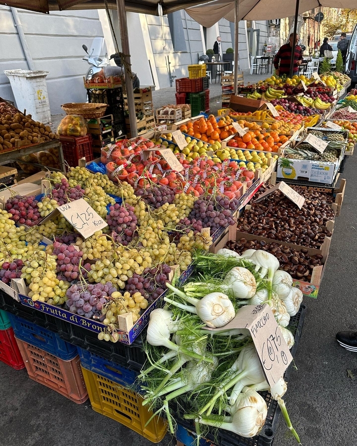 Un étal de marché coloré présentant des produits frais et des fruits.