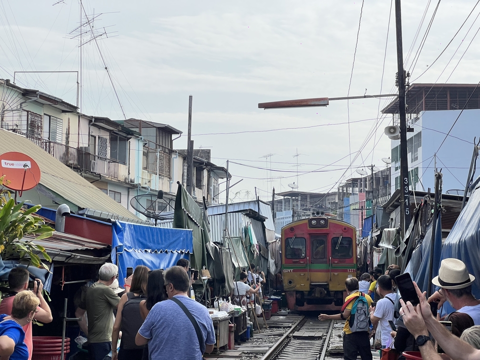 Train passant à travers un marché de rue bondé.