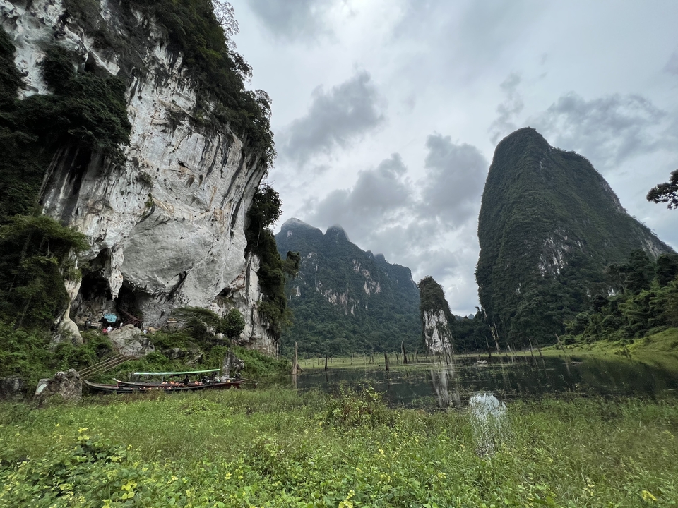 Dramatic landscape with towering cliffs and lush greenery.