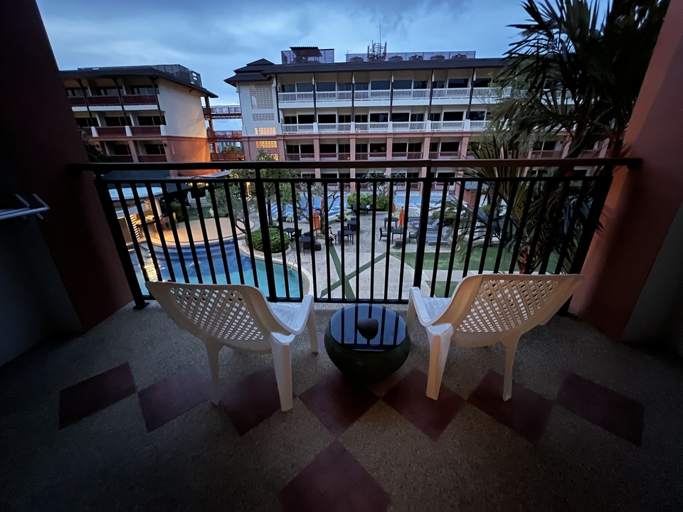 Vue du balcon d'un complexe hôtelier avec piscine.