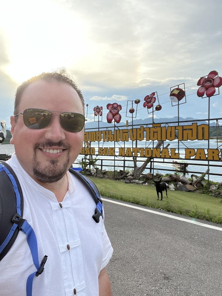 Man taking a selfie at Khao Sok National Park entrance.