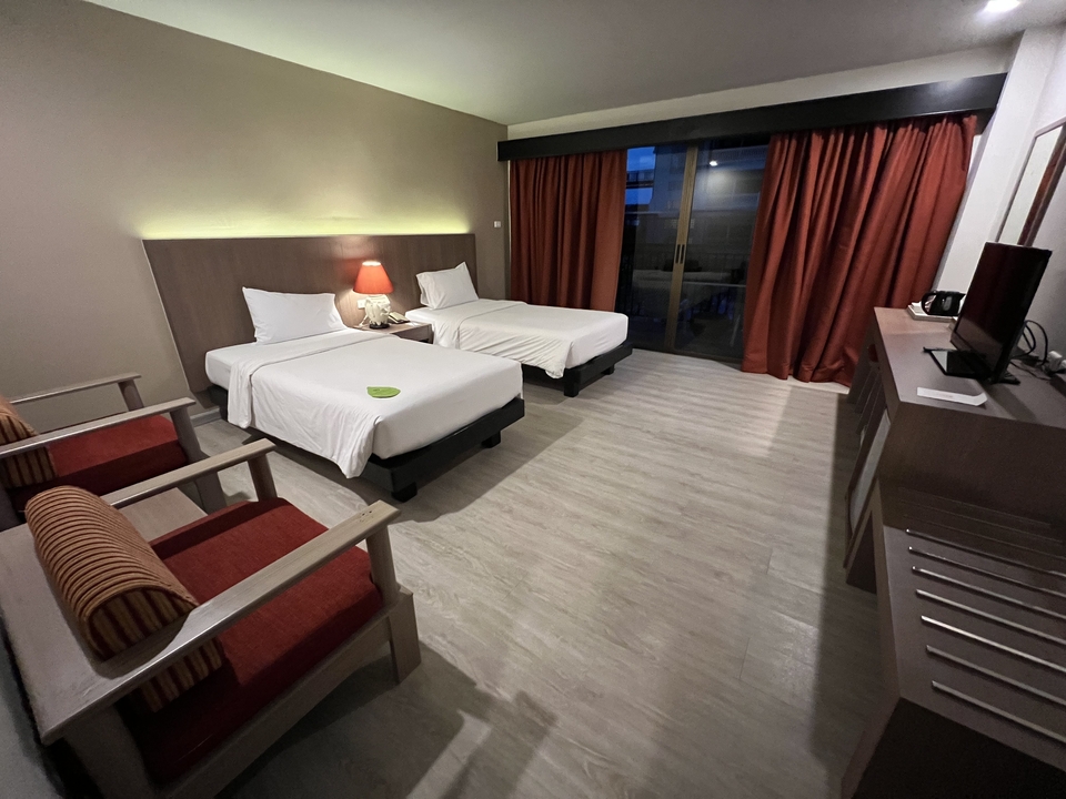 Hotel room with two twin beds and modern decor.
