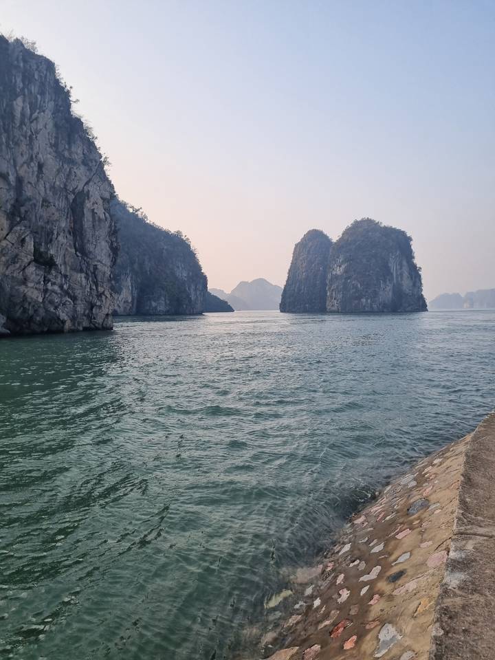 Formations rocheuses dans l'eau avec un arrière-plan montagneux.