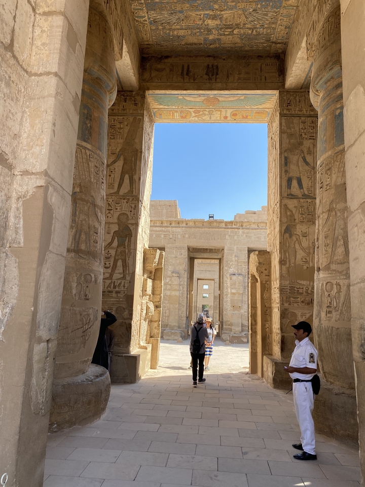 Des personnes examinant d'anciens hiéroglyphes sur les murs du temple.