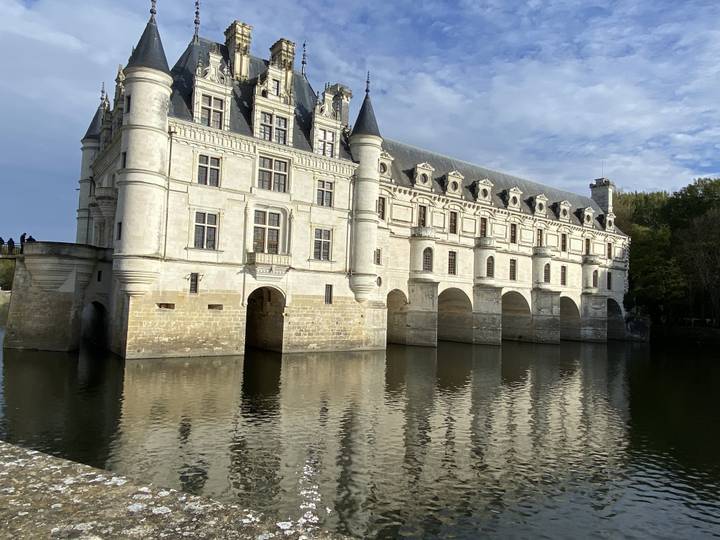 Château historique avec arches reflété dans l'eau.