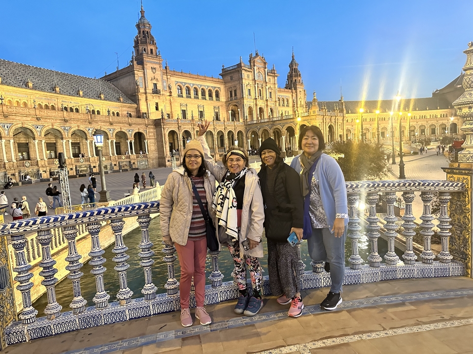 Groupe de femmes sur un balcon avec bâtiment historique