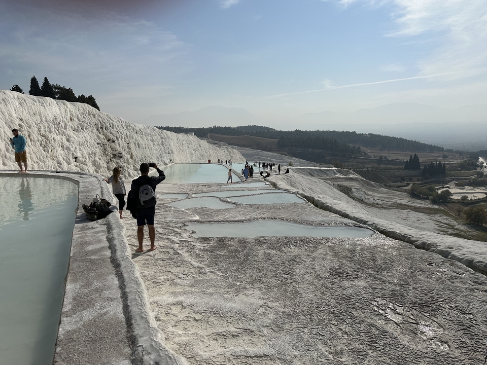 Des touristes explorant des terrasses calcaires et des bassins.
