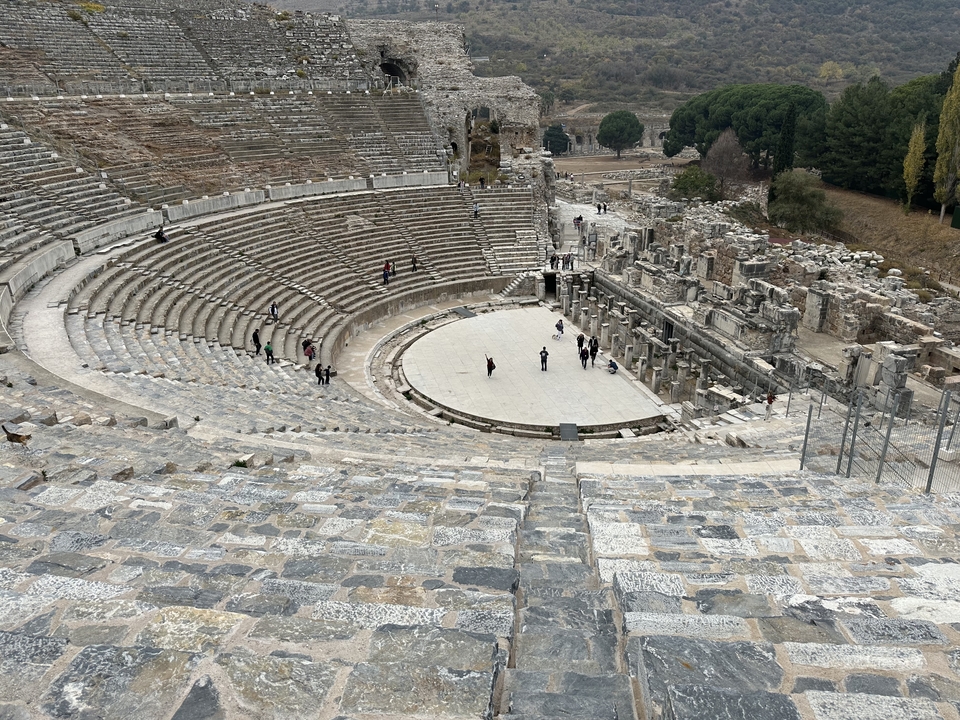Amphithéâtre antique avec des personnes marchant sur les marches.