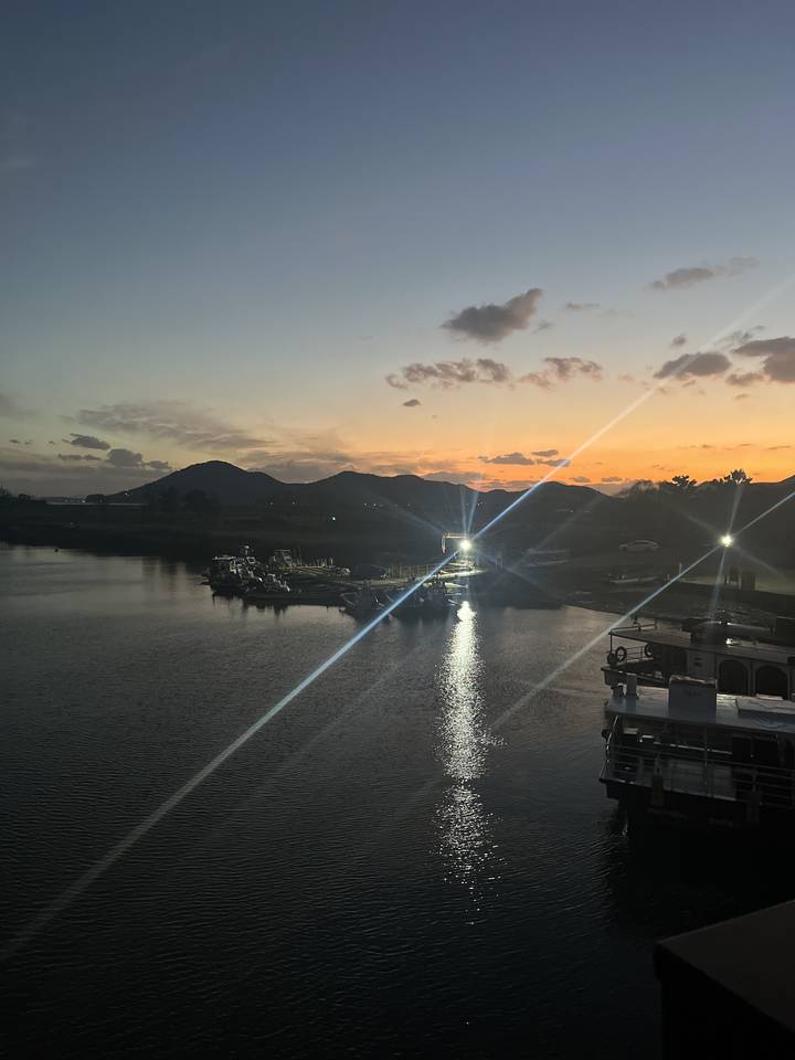 Vue du coucher de soleil avec un bateau sur un plan d'eau.