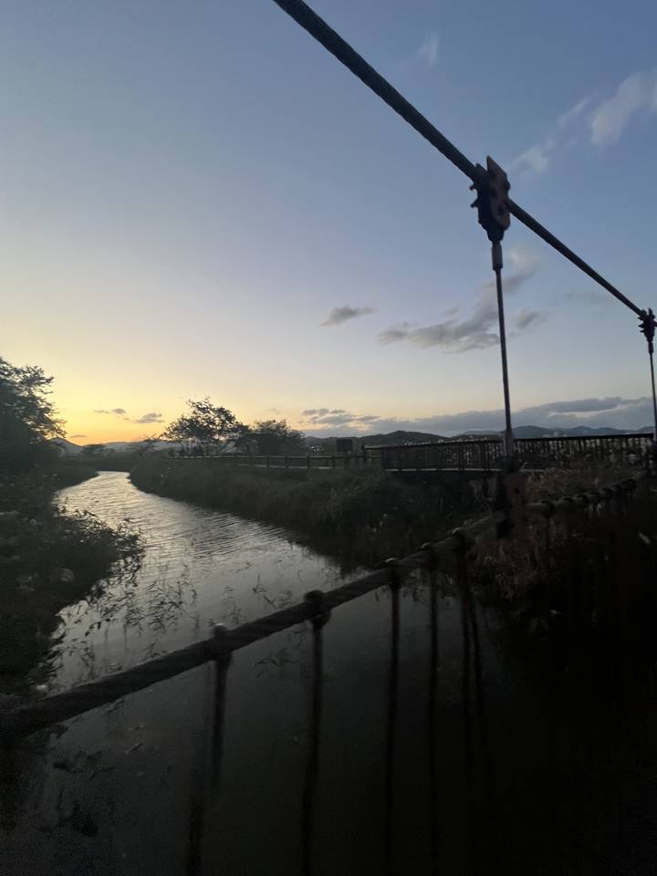 Un paysage de rivière et pont au coucher du soleil.