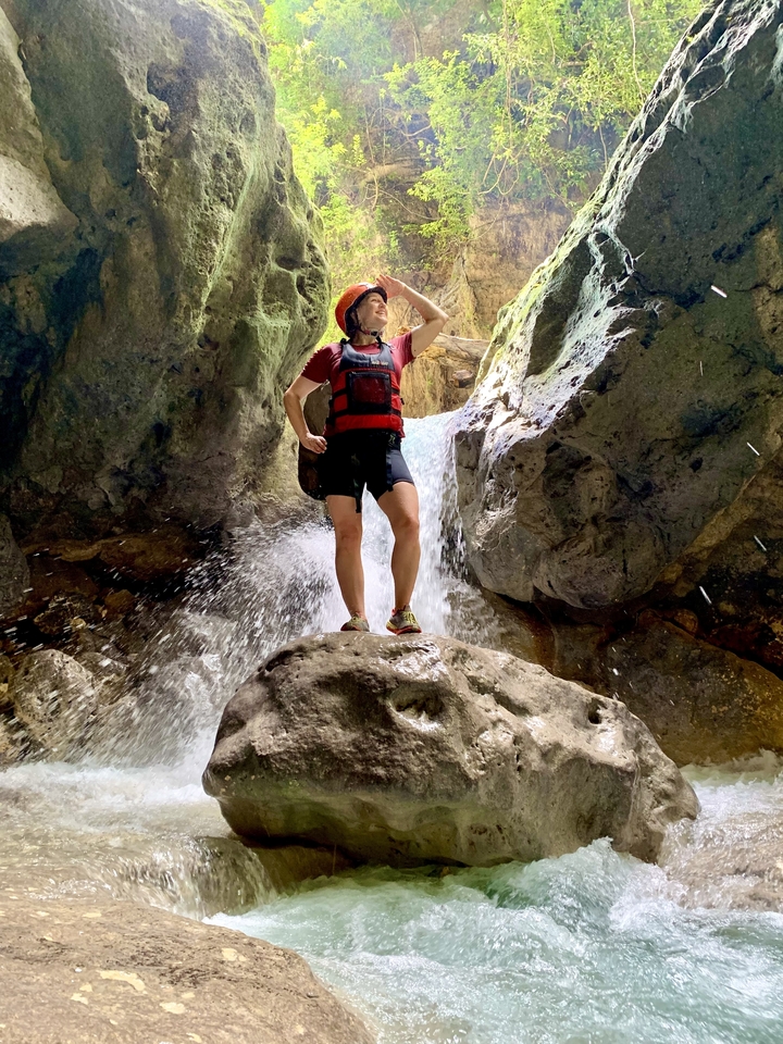 Personne debout dans une grotte avec de l'eau qui coule.
