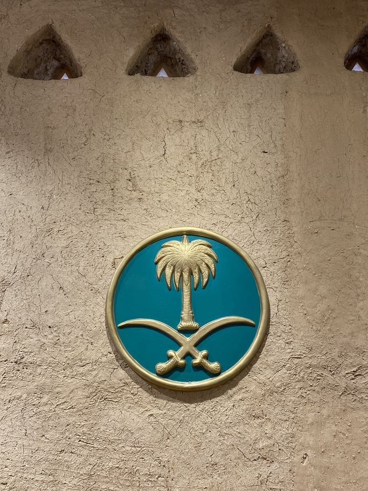 Un emblème de palmier sur un mur texturé.