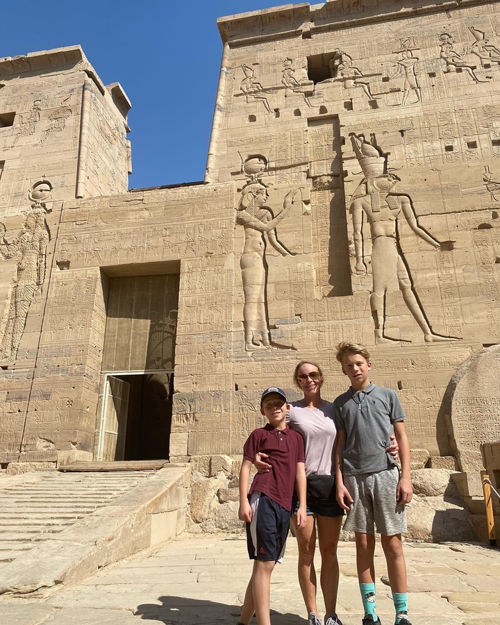 Photo de famille devant un temple ancien.