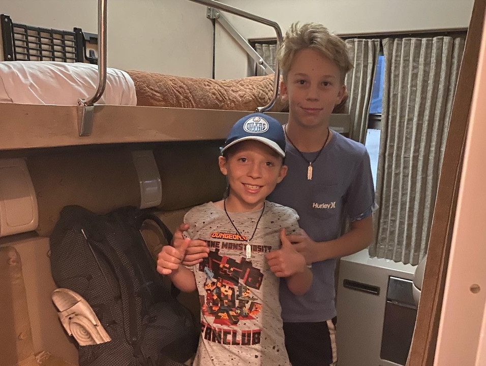 Des enfants debout dans une cabine de train.